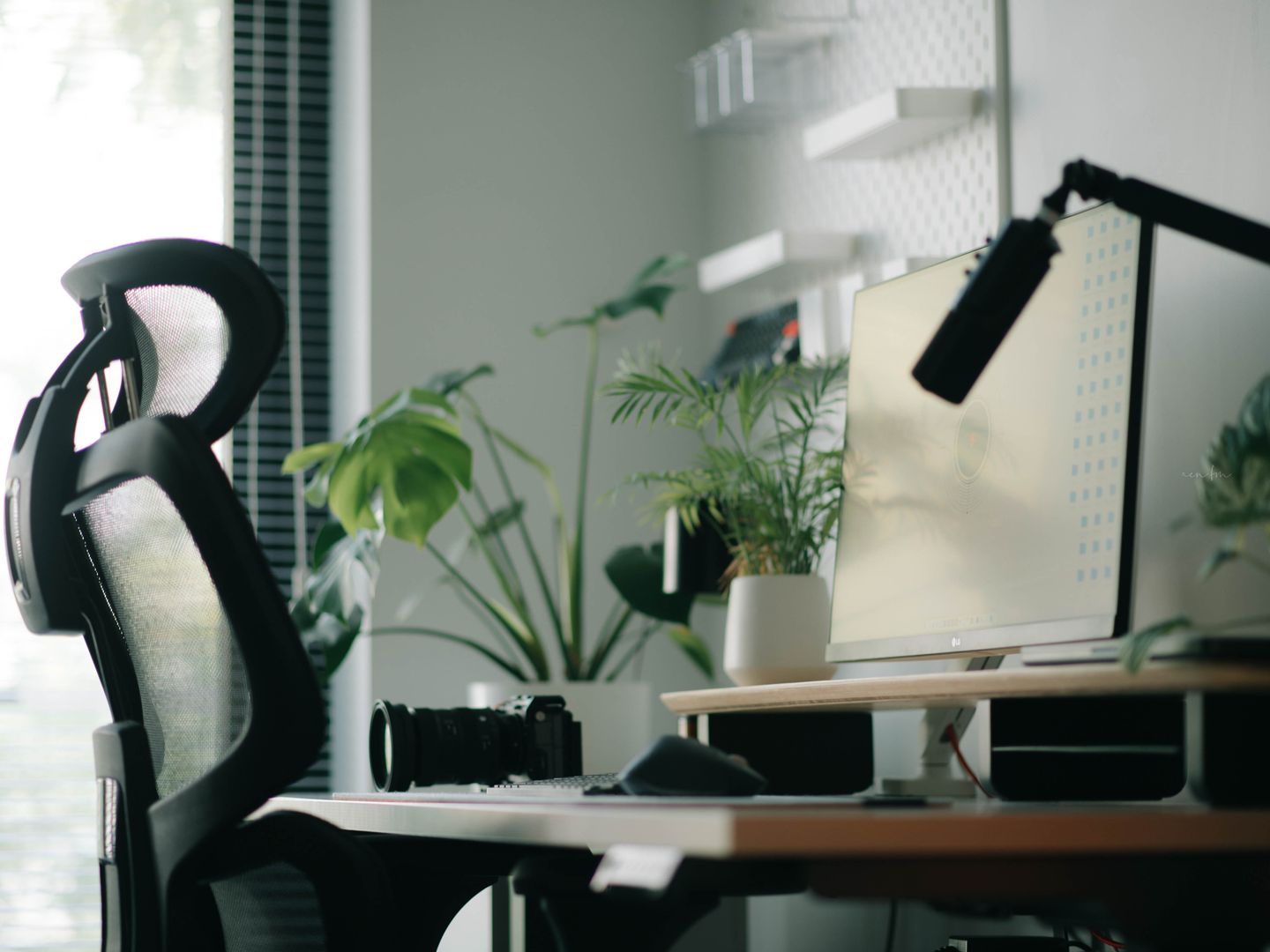 A stylish home office featuring an ergonomic chair, computer setup, and indoor plants, ideal for work inspiration.