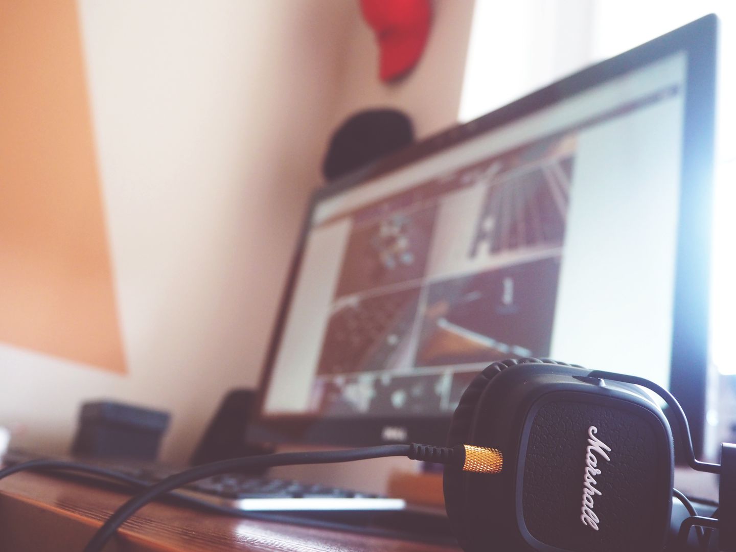 A contemporary desk setup featuring headphones and a computer screen displaying digital content.
