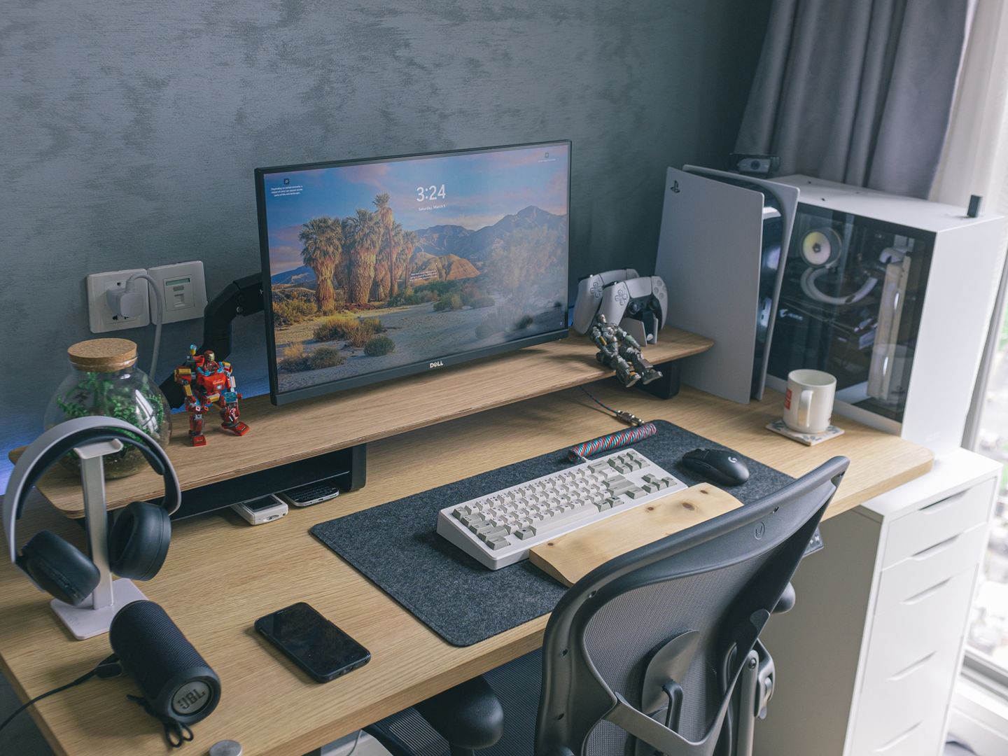 A sleek home office featuring a gaming console, monitor, keyboard, and desk accessories, ideal for technology enthusiasts.